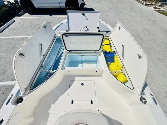 Slide: The Image of 2021 Sea Born FX24 boat with open storage compartments and seating area. - 15