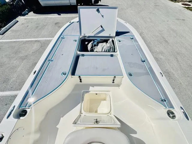 Slide: The Image of 2021 Sea Born FX24 boat deck with open storage compartments in a parking lot. - 16