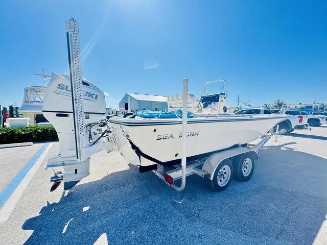 Slide: The Image of 2021 Sea Born FX24 boat on trailer with Suzuki outboard motor, parked under clear blue sky. - 20