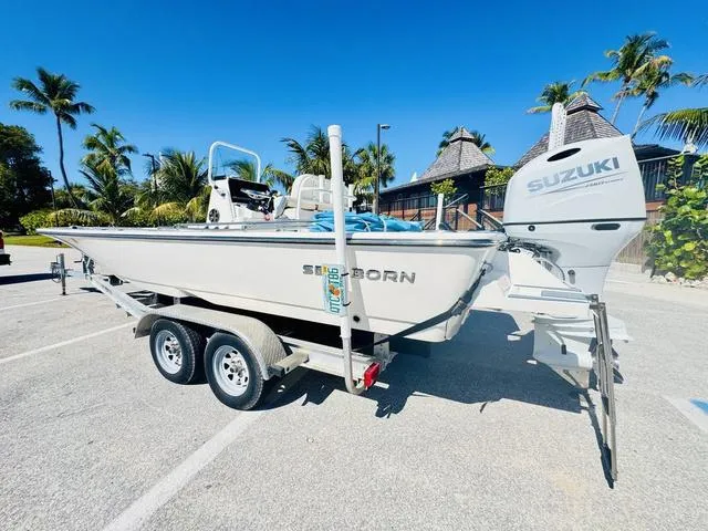 Slide: The Image of 2021 Sea Born FX24 boat with Suzuki engine on trailer, parked in tropical setting. - 3