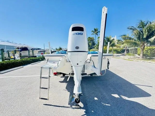 Slide: The Image of 2021 Sea Born FX24 boat with 200 HP engine, parked outdoors under clear blue sky. - 4