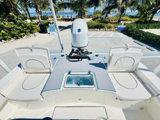 Slide: The Image of 2021 Sea Born FX24 boat interior with seating and motor, near a beach setting. - 7