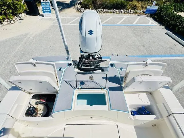 Slide: The Image of 2021 Sea Born FX24 boat with open storage compartments and Suzuki outboard motor. - 8