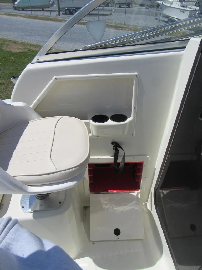 Slide: The Image of 2002 Fish Hawk 210 WA boat interior with seat, cup holders, and storage compartment. - 10