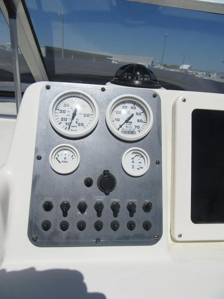 Slide: The Image of Instrument panel of a 2002 Fish Hawk 210 WA boat with gauges and controls. - 13