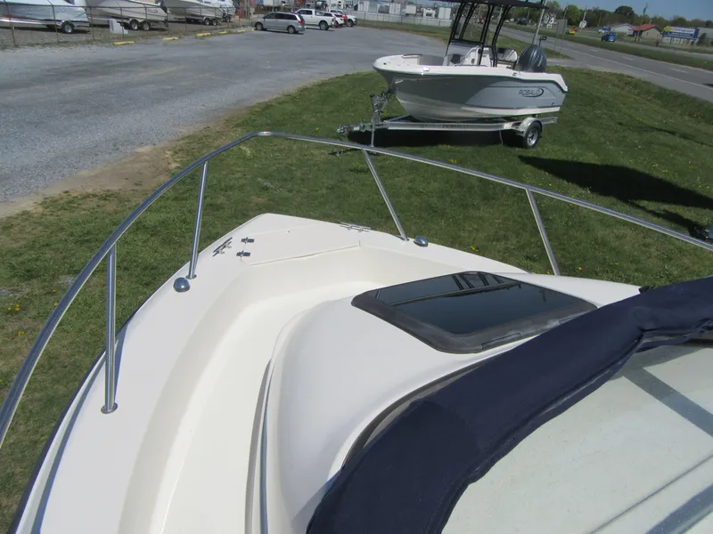 Slide: The Image of 2002 Fish Hawk 210 WA boat on grass, with another boat in the background. - 18
