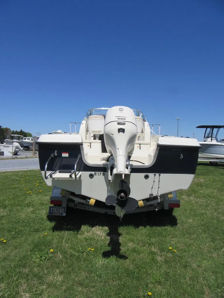 Slide: The Image of 2002 Fish Hawk 210 WA boat, rear view, on grass with clear blue sky. - 2