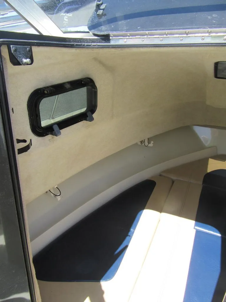 Slide: The Image of Interior view of 2002 Fish Hawk 210 WA boat cabin with window and seating. - 22