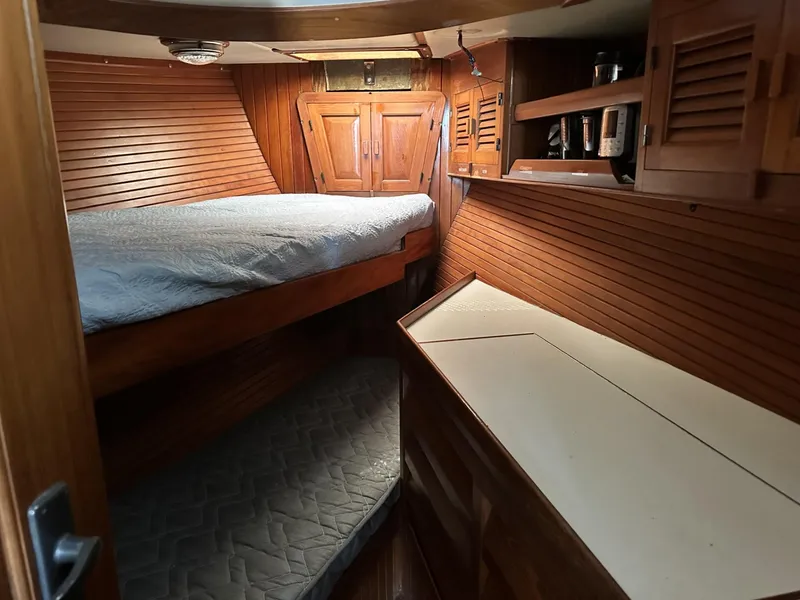 Slide: The Image of Cozy wooden cabin interior of 1986 Slocum 43 sailboat with bed and storage. - 18