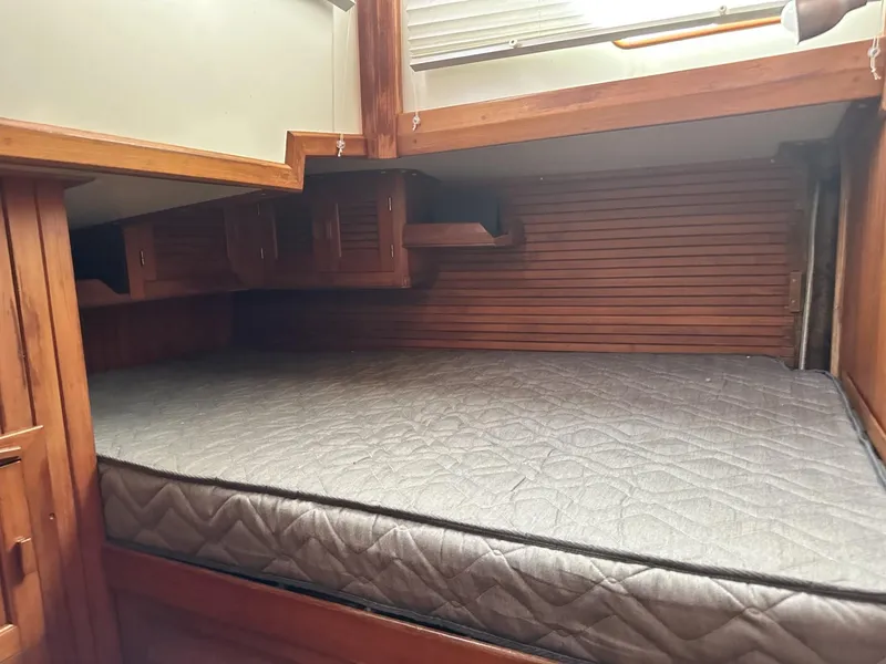 Slide: The Image of 1986 Slocum 43 yacht interior with wooden cabinetry and a comfortable bed. - 20