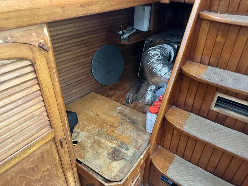 Slide: The Image of 1986 Slocum 43 yacht interior with wooden stairs and storage area. - 22