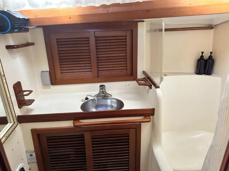 Slide: The Image of 1986 Slocum 43 yacht bathroom with wooden cabinets and stainless steel sink. - 23