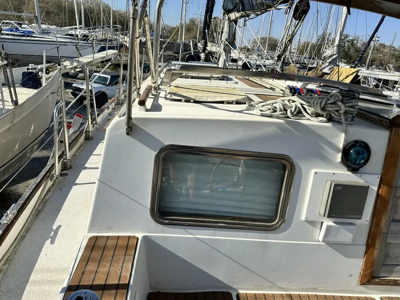 Slide: The Image of 1986 Slocum 43 sailboat deck with ropes and window, docked among other boats. - 29