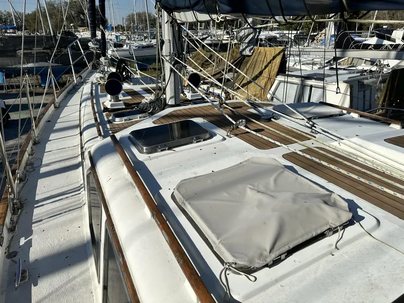 Slide: The Image of 1986 Slocum 43 sailboat deck with rigging and hatches in a marina setting. - 31