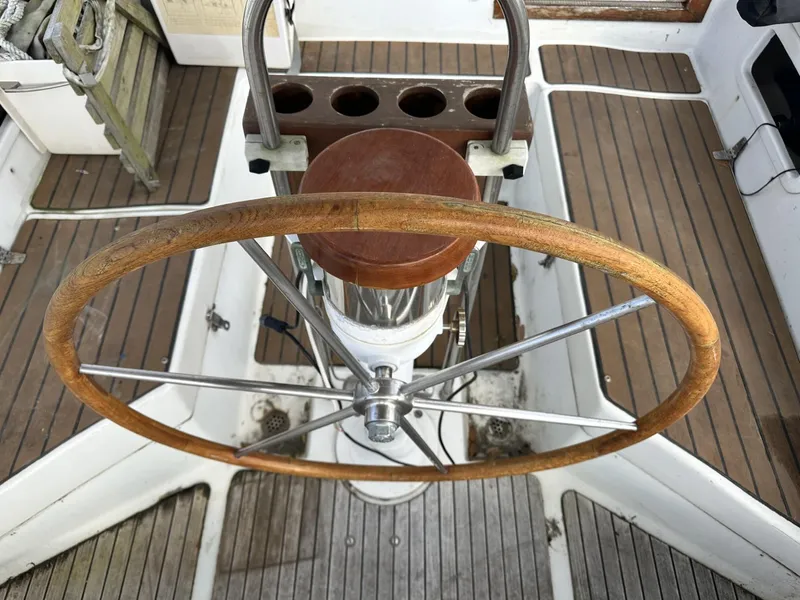 Slide: The Image of Wooden steering wheel on 1986 Slocum 43 sailboat, featuring teak deck and metal fittings. - 7