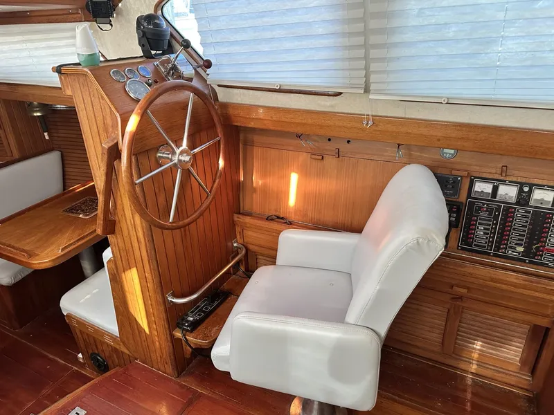 Slide: The Image of Interior of 1986 Slocum 43 sailboat with wooden helm and white captain's chair. - 9