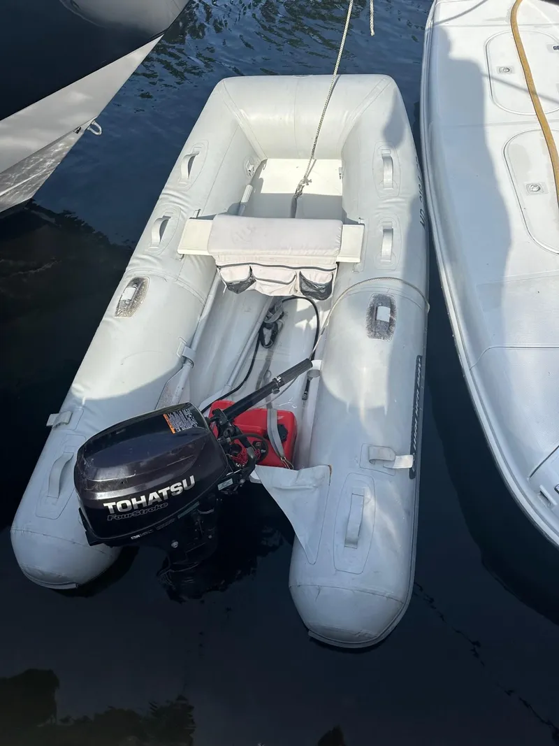 Slide: The Image of Inflatable dinghy with Tohatsu motor beside Carver 450 Voyager. - 6