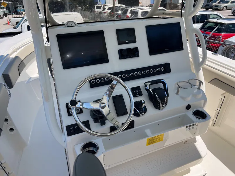 Slide: The Image of 2025 Key West 260 Center Console boat dashboard with steering wheel and electronic displays. - 11
