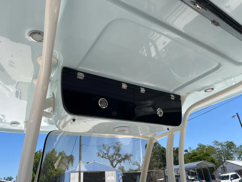 Slide: The Image of 2025 Key West 260 Center Console boat's overhead storage compartment, featuring sleek black doors. - 12