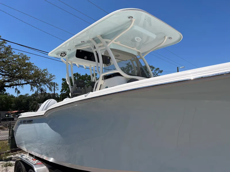 Slide: The Image of 2025 Key West 260 Center Console boat with sleek design and T-top, parked outdoors. - 7