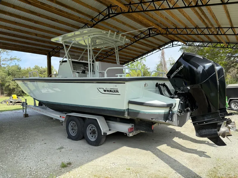 Slide: The Image of 2004 Boston Whaler Guardian 27 boat on trailer under a metal canopy. - 1