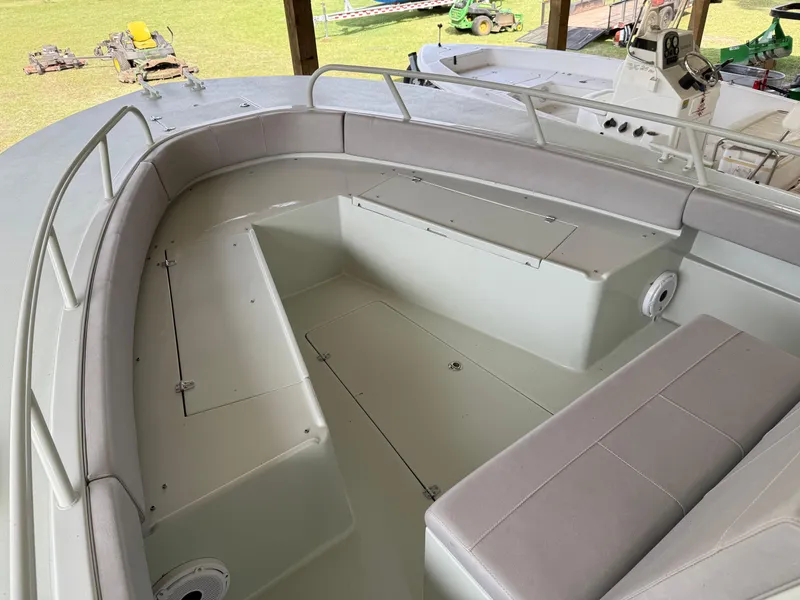 Slide: The Image of 2004 Boston Whaler Guardian 27 boat interior with cushioned seating and storage compartments. - 10