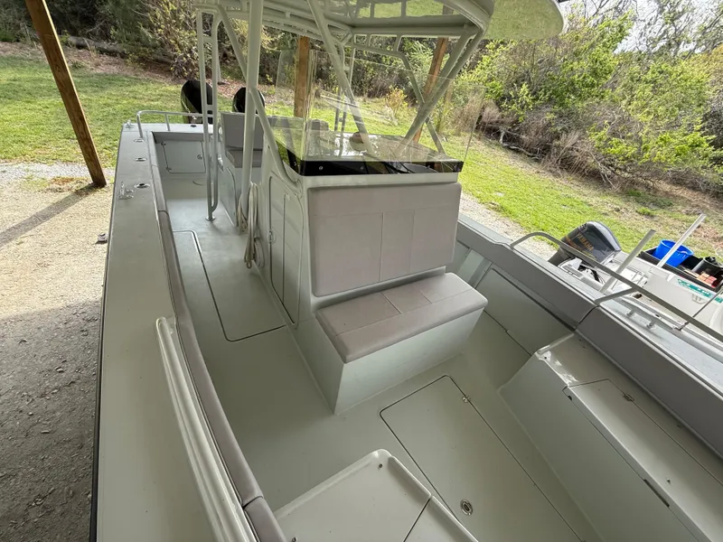 Slide: The Image of 2004 Boston Whaler Guardian 27 boat interior with seating and console, parked outdoors. - 12