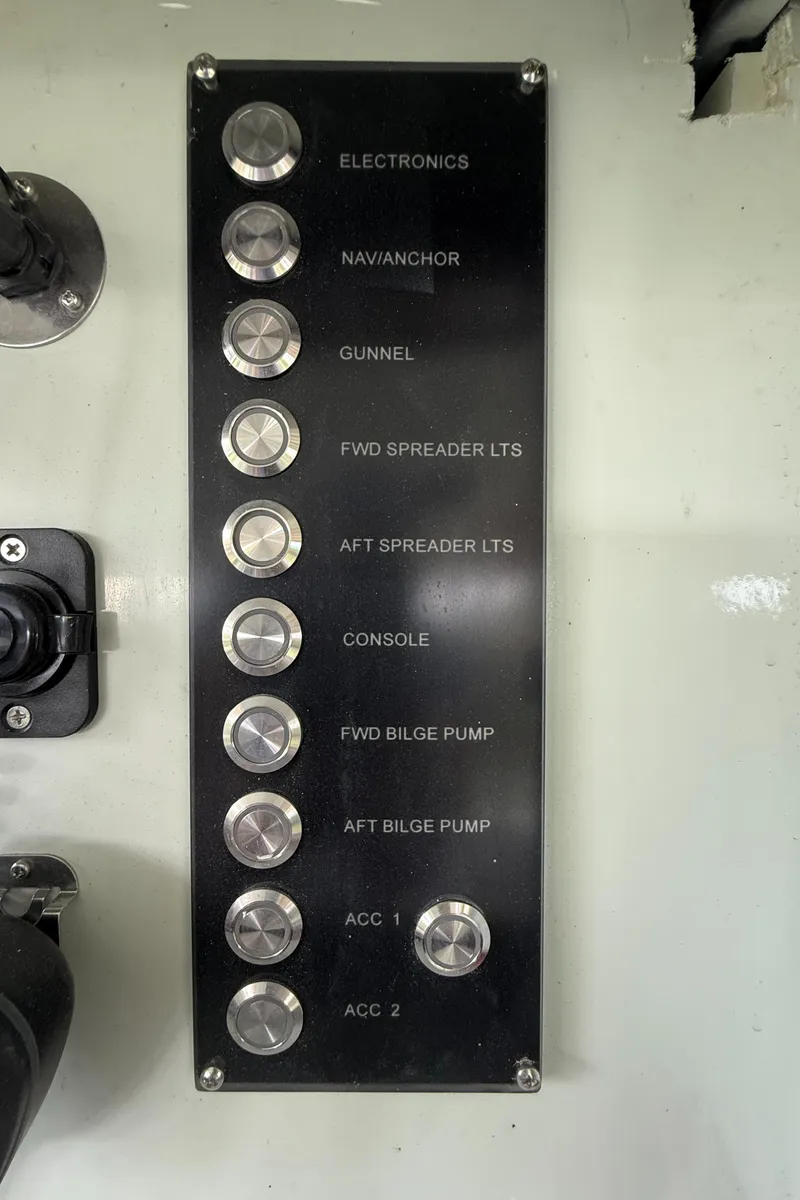 Slide: The Image of Control panel of a 2004 Boston Whaler Guardian 27 boat with labeled switches. - 18