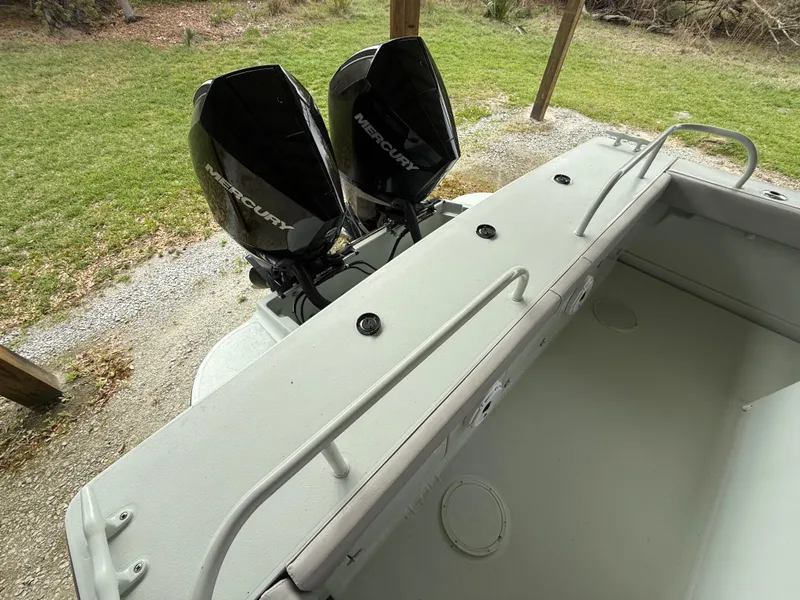 Slide: The Image of 2004 Boston Whaler Guardian 27 with dual Mercury outboard engines, docked on grassy area. - 21