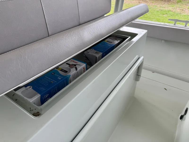 Slide: The Image of Storage compartment in a 2004 Boston Whaler Guardian 27 boat, containing packaged items. - 27