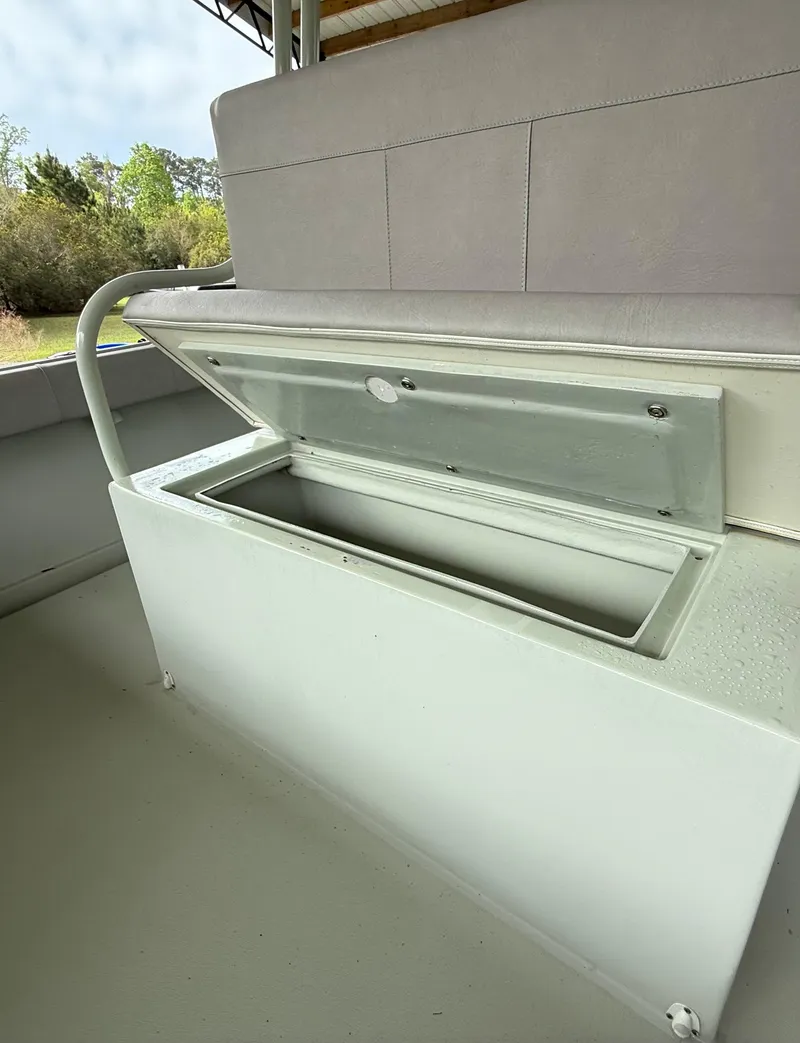 Slide: The Image of 2004 Boston Whaler Guardian 27 storage compartment with open lid, showcasing interior space. - 29