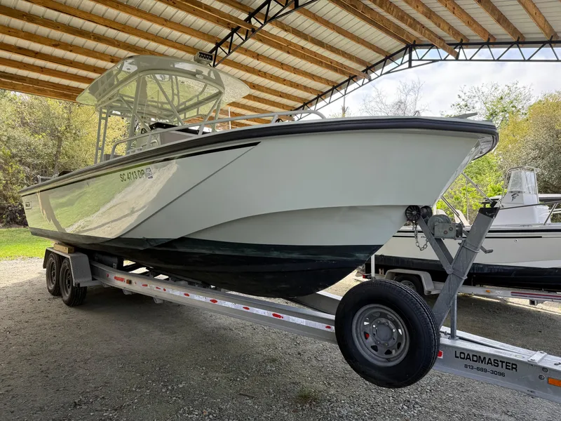 Slide: The Image of 2004 Boston Whaler Guardian 27 on trailer under a metal canopy. - 3