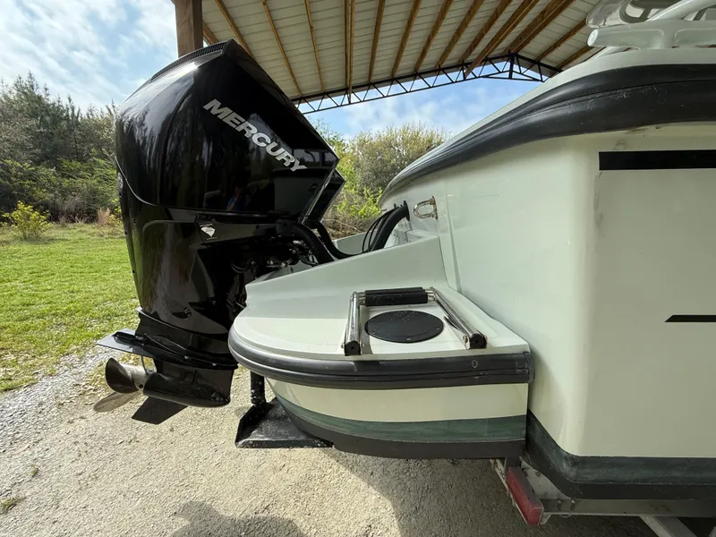 Slide: The Image of 2004 Boston Whaler Guardian 27 with Mercury outboard engine under a metal canopy. - 4