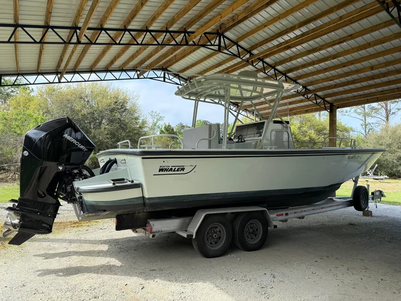Slide: The Image of 2004 Boston Whaler Guardian 27 boat on trailer under a metal canopy. - 5