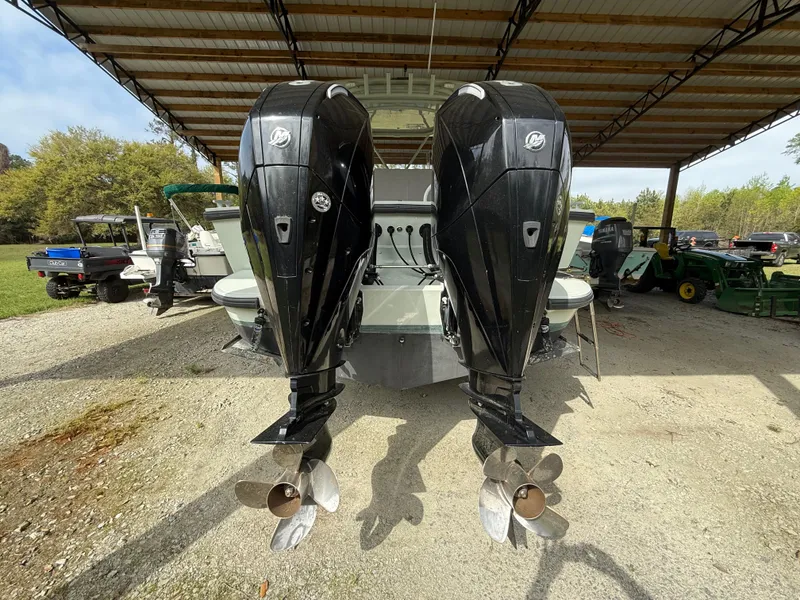 Slide: The Image of Twin outboard motors on a 2004 Boston Whaler Guardian 27 under a metal canopy. - 7