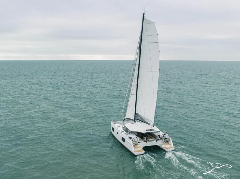 Slide: The Image of 2025 Nautitech 40 Open catamaran sailing on open sea under cloudy skies. - 3