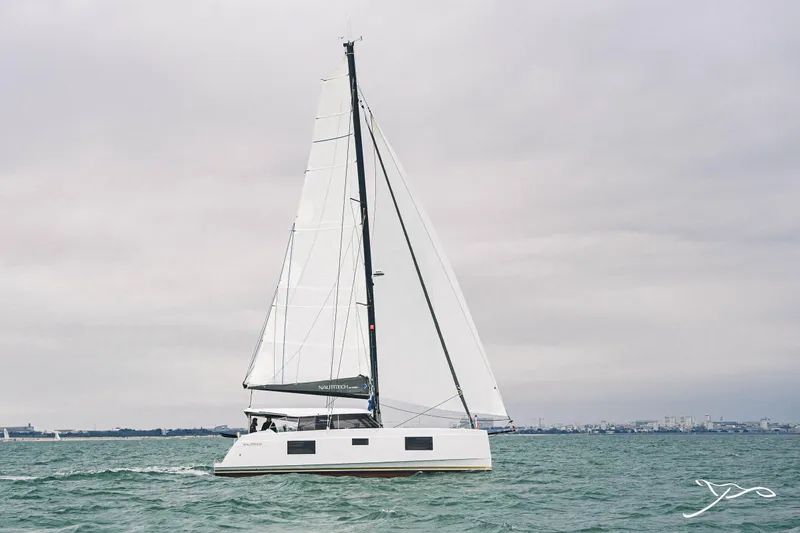 Slide: The Image of 2025 Nautitech 40 Open catamaran sailing on calm waters under cloudy skies. - 4
