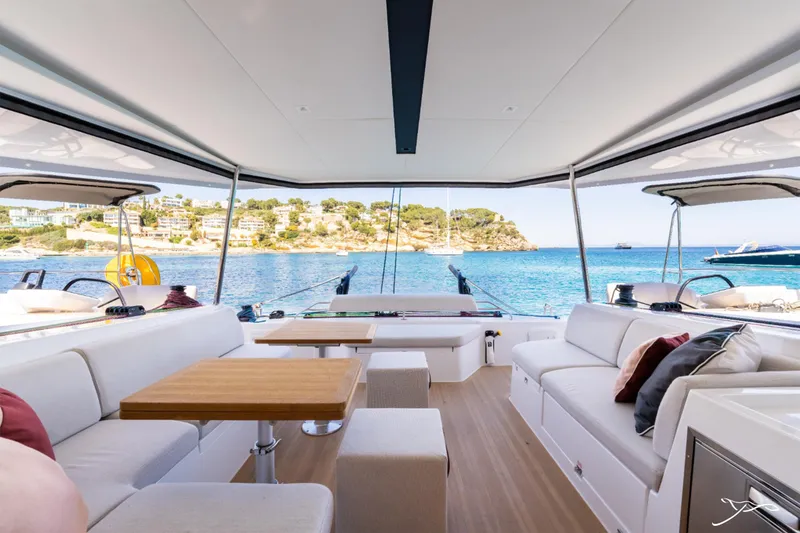 Slide: The Image of Luxurious Nautitech 44 Open yacht interior with ocean view, featuring modern seating and wooden table, 2025 model. - 24