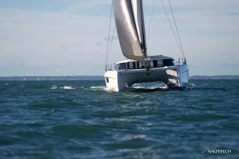 Slide: The Image of 2025 Nautitech 48 Open catamaran sailing on open water. - 13