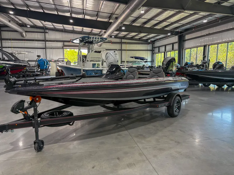 Slide: The Image of 2025 Skeeter ZX150 boat in showroom, sleek design, on trailer. - 2