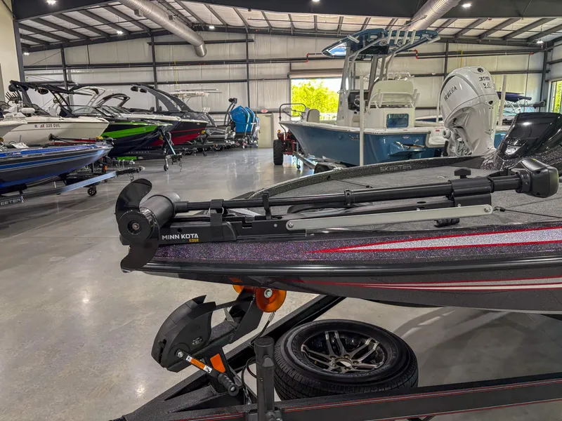 Slide: The Image of 2025 Skeeter ZX150 boat in showroom with other models, featuring a Minn Kota trolling motor. - 7