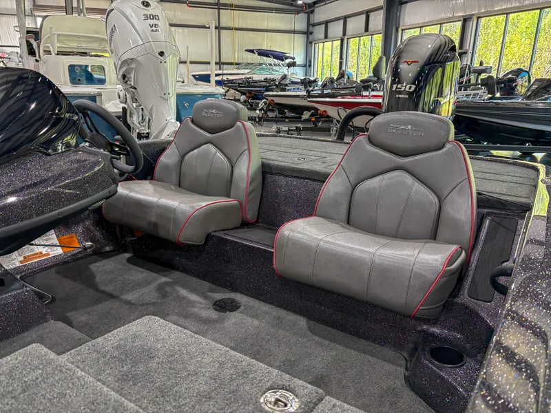 Slide: The Image of 2025 Skeeter ZX150 boat interior with dual gray seats in showroom. - 8