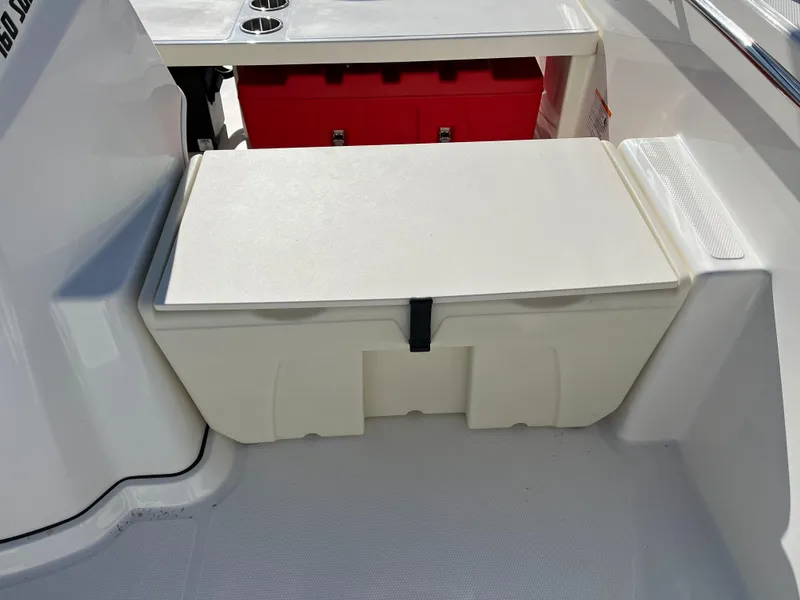 Slide: The Image of 2025 Boston Whaler 160 Super Sport boat interior with storage compartment and red cooler. - 12