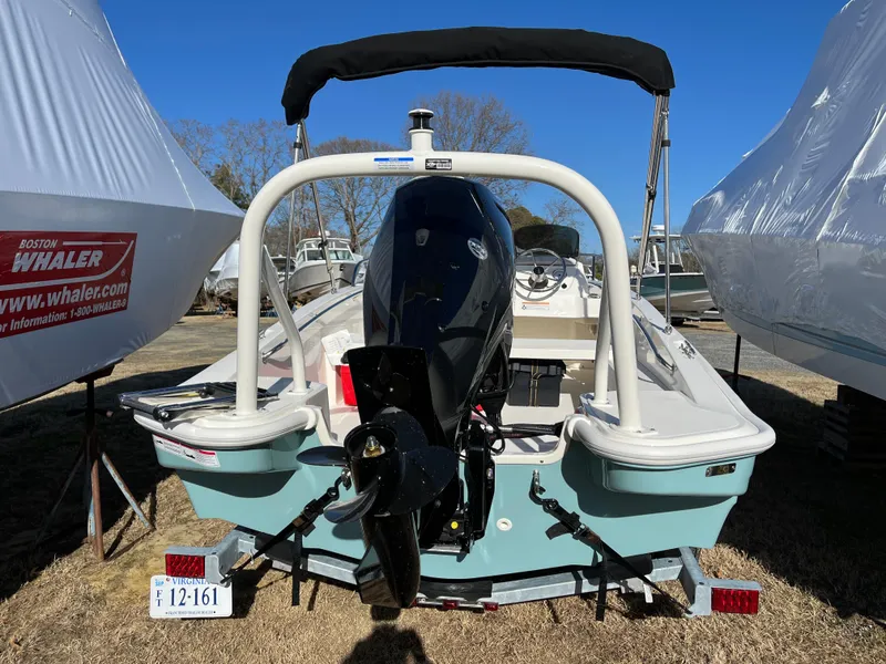 Slide: The Image of 2025 Boston Whaler 160 Super Sport boat with outboard motor, parked outdoors. - 16