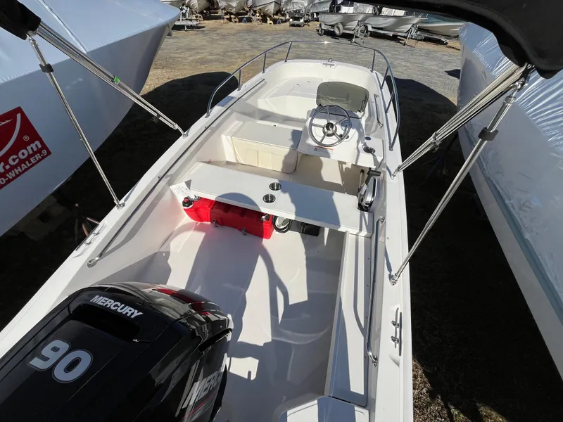 Slide: The Image of 2025 Boston Whaler 160 Super Sport boat with Mercury 90 engine, docked outdoors. - 5