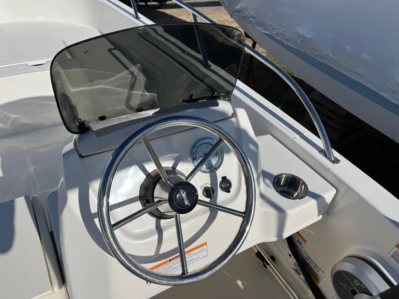 Slide: The Image of 2025 Boston Whaler 160 Super Sport boat dashboard with steering wheel and controls. - 6
