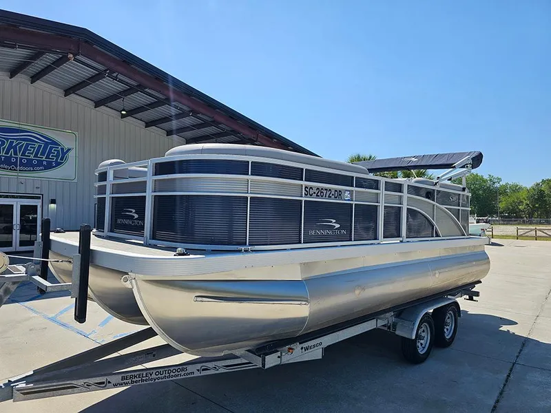 Slide: The Image of 2021 Bennington 20 SSR pontoon boat on trailer outside dealership. - 2