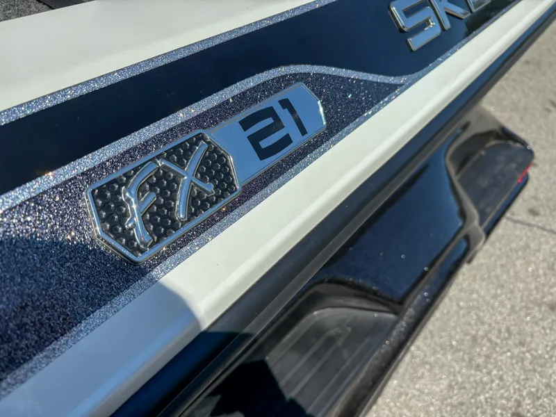 Slide: The Image of 2014 Skeeter FX 21 boat emblem with metallic finish on a sleek surface. - 2