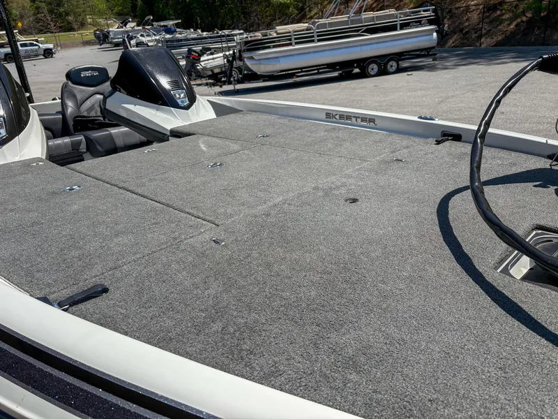 Slide: The Image of 2014 Skeeter FX 21 boat with spacious deck and seating, parked outdoors. - 9
