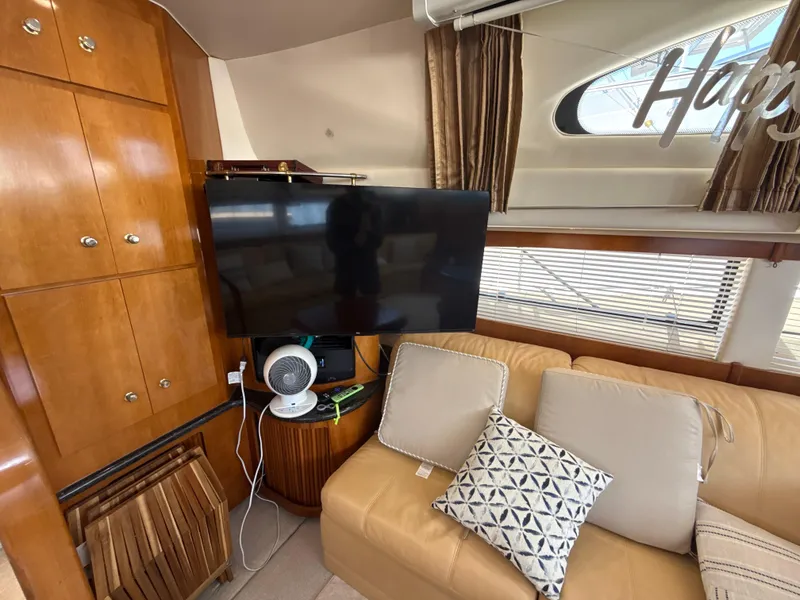 Slide: The Image of Interior of 2001 Carver 396 Motor Yacht with TV, sofa, and wooden cabinets. - 19